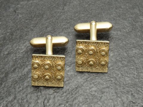 Manschettenknöpfe vergoldet klein pfiffig 70er selten vom Hersteller Juwelier Harnisch in goldfarben mit einer strukturierten Oberfläche und runden Akzenten.
