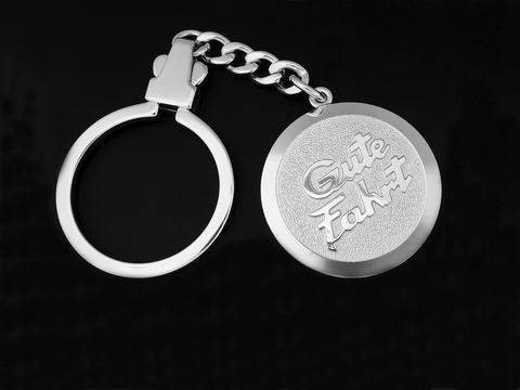 Schlüsselanhänger Gute Fahrt aus rhodiniertem Sterling Silber, Hersteller Juwelier Harnisch, ideal als Geschenkidee, mit prägnanter Schriftzugprägung auf der runden Medaille.