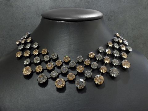 Edelstein-Halskette in champagner-grau mit schwarzer Fassung, hergestellt von Juwelier Harnisch, in der Größe 42,5-46 cm, funkelt elegant auf einem schwarzen Schmuckdisplay.