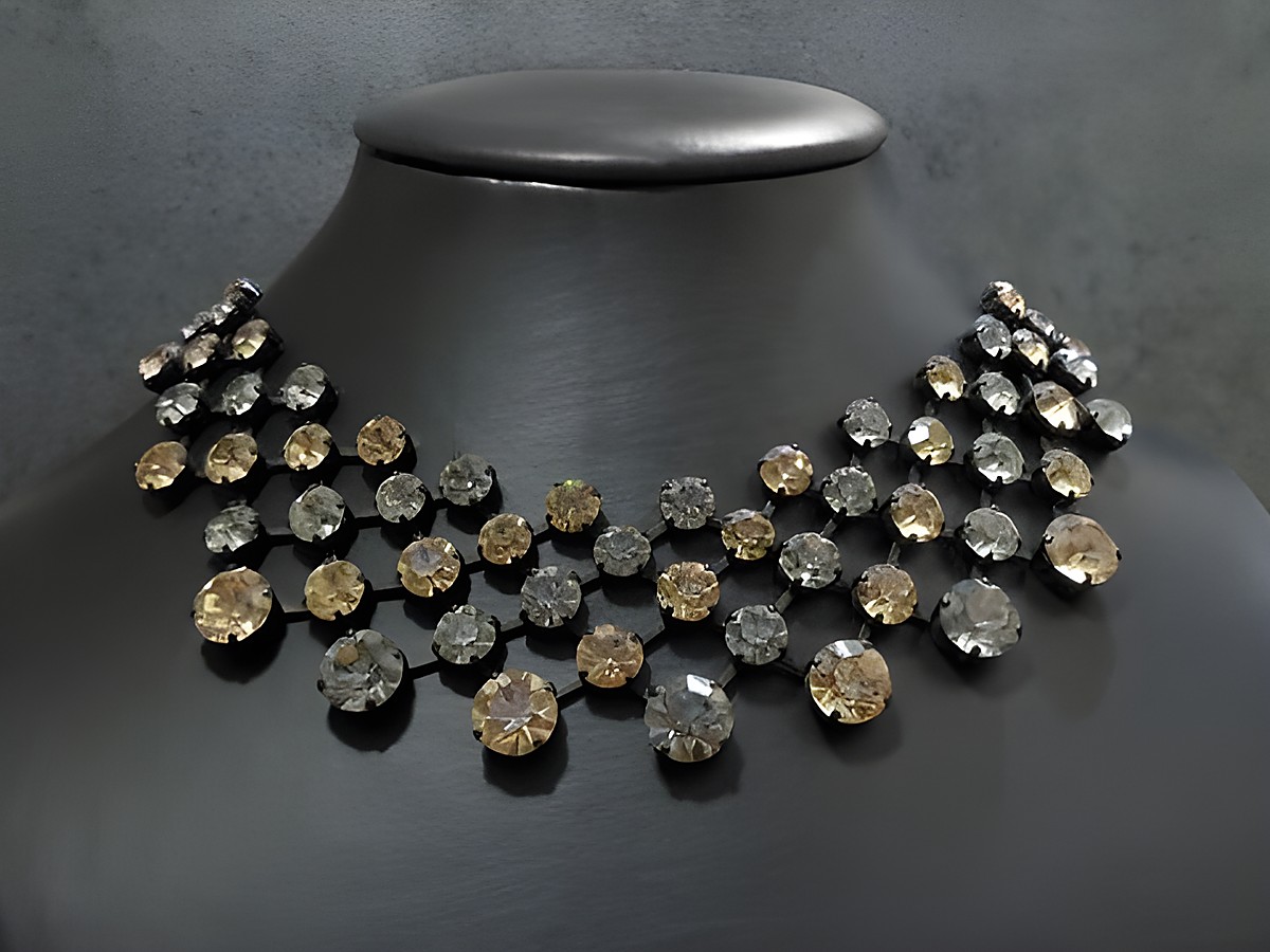 Edelstein-Halskette in champagner-grau mit schwarzer Fassung, hergestellt von Juwelier Harnisch, in der Größe 42,5-46 cm, funkelt elegant auf einem schwarzen Schmuckdisplay.