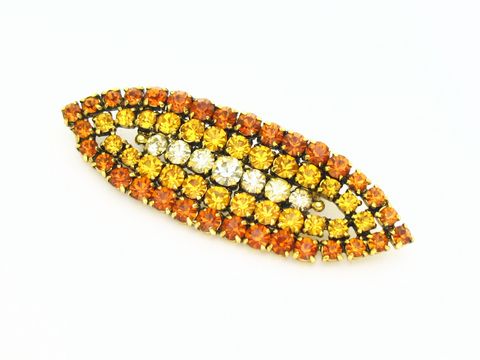 Brosche Sexy City Look Einzelstück in Orange, hergestellt von Juwelier Harnisch. Strass Brosche in Gelb und Braun mit glitzernden Steinen in mehreren Reihen angeordnet, ideal für auffällige Outfits.