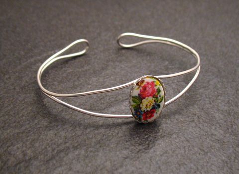 Ein feiner Armreifen aus sterling Silber mit einem ovalen Cabochon, der ein florales Muster zeigt. Der Umfang beträgt 17 cm und stammt vom Hersteller Juwelier Harnisch.