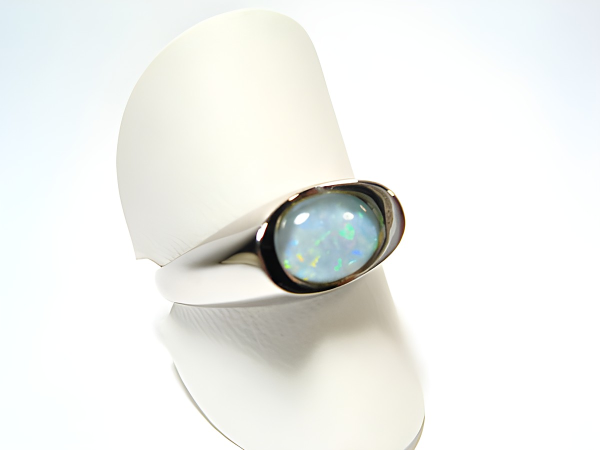 Silber Designer Ring rhodiniert mit buntem Opal-Triplette, verstellbar und hergestellt von Juwelier Harnisch, elegant auf einem farblich neutralen Präsentationsstütze platziert.