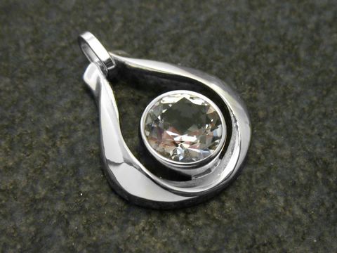 Designer Goldanhänger aus 18 mm Weißgold mit einem zentralen Bergkristall. Der Anhänger hat eine elegante Tropfenform und glänzende Oberflächen, ideal für modebewusste Träger.
