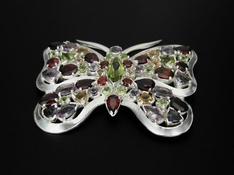 Schmetterling aus Silber mit facettierten Granaten, Peridot und Amethyst, Hersteller Juwelier Harnisch, kunstvolle Brosche in filigraner Verarbeitung.