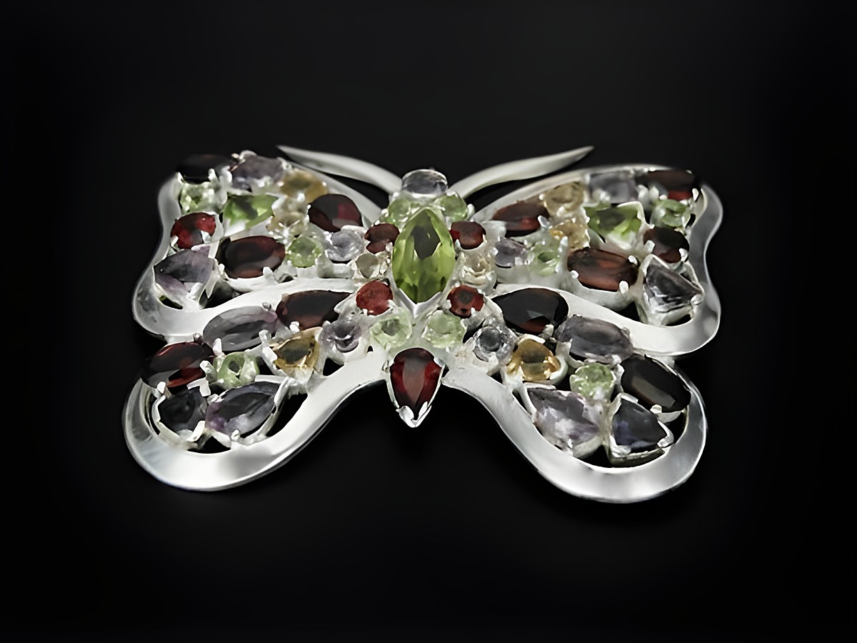 Schmetterling aus Silber mit facettierten Granaten, Peridot und Amethyst, Hersteller Juwelier Harnisch, kunstvolle Brosche in filigraner Verarbeitung.