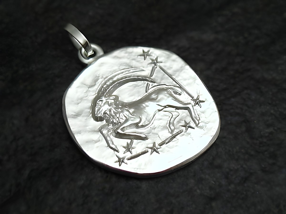Steinbock Sternzeichen Anhänger aus rhodiniertem Sterling Silber, gefertigt von Juwelier Harnisch, zeigt detaillierte Gravur eines Steinbocks umgeben von Sternen.