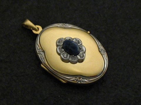 Medaillon aus Gold 585 bicolor mit Sodalit blau Cabochon, umgeben von einer blütenförmigen Anordnung und feinen Details, hergestellt von Juwelier Harnisch.