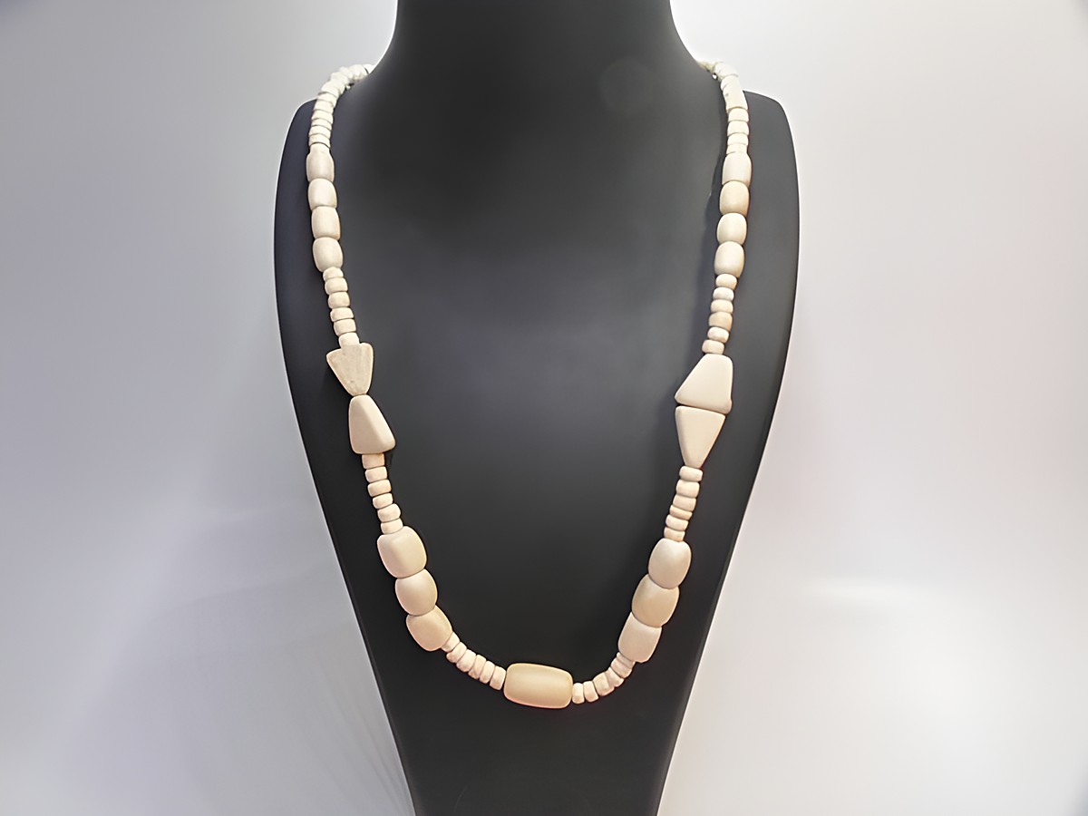 Holzkette Multiform 19 mm naturbraun 60 cm Holz Schmuck von Juwelier Harnisch in naturbraun, aus verschiedenen Holzformen, elegant drapiert auf einem Schmuckständer.