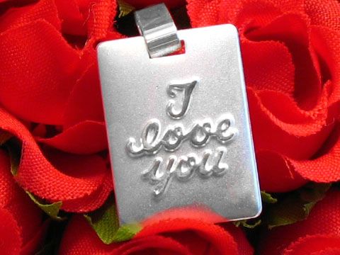 Silber Gravurplatte Rechteck I LOVE YOU mattiert, Hersteller Juwelier Harnisch, liegt auf roten Rosen und zeigt den liebevollen Text in geschwungener Schrift.