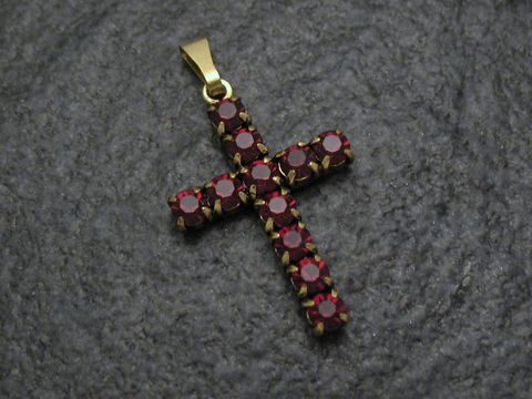 Roter Strass Anhänger im sexy City Look in Kreuzform, gefertigt vom Juwelier Harnisch, besticht durch funkelnde rote Strasssteine, ideal für stilvolle Akzente.
