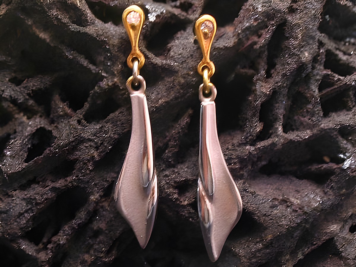 Weibliche Gold 585 Ohrhänger bicolor von Juwelier Harnisch ohne Stein, in eleganter Form mit geschwungenem Design, auf dunklem Hintergrund präsentiert.