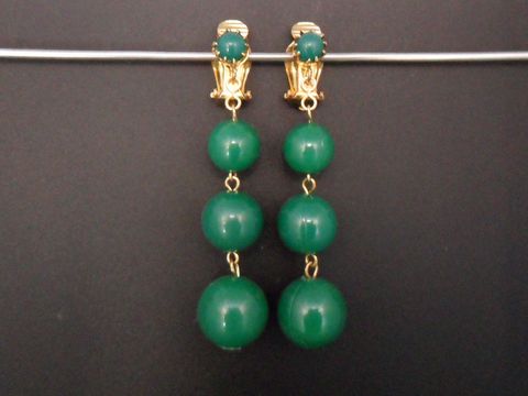 Ohrclip in zeitlosem Design mit grünem Kunstharz, goldfarbenen Elementen und eleganter Form, hergestellt von Juwelier Harnisch. Ideal für jeden Anlass und stilvolle Akzente.