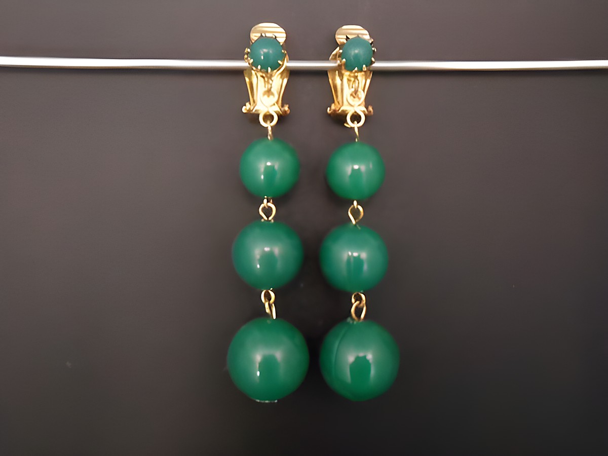 Ohrclip in zeitlosem Design mit grünem Kunstharz, goldfarbenen Elementen und eleganter Form, hergestellt von Juwelier Harnisch. Ideal für jeden Anlass und stilvolle Akzente.