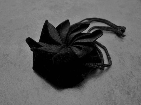 65360-0 Geschenksäckchen rund aus schwarzem Samt, ideal für Schmuckaufbewahrung, Hersteller Juwelier Harnisch, hochwertiges Design mit eleganter Schleife, perfekt für besondere Anlässe.