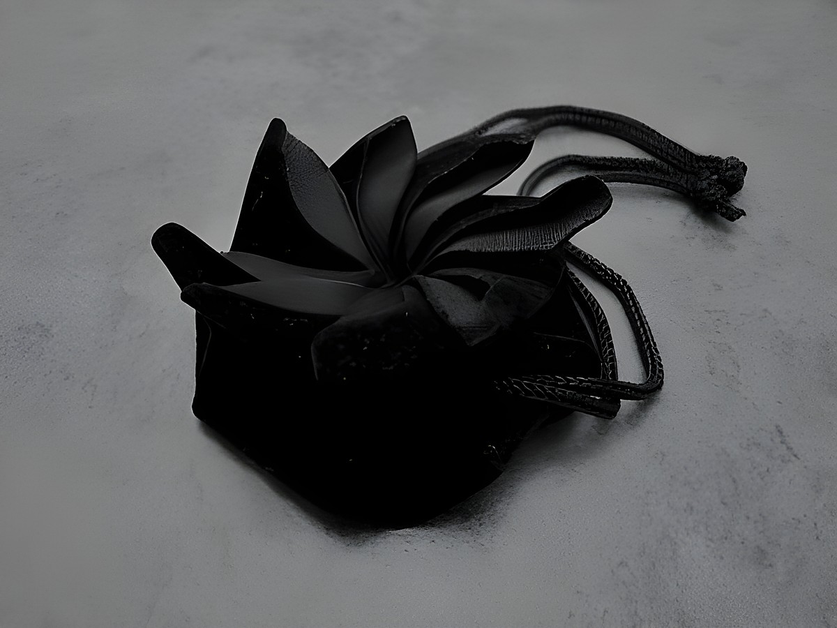 Geschenksäckchen rund aus schwarzem Samt, ideal für Schmuckaufbewahrung, Hersteller Juwelier Harnisch, hochwertiges Design mit eleganter Schleife, perfekt für besondere Anlässe.
