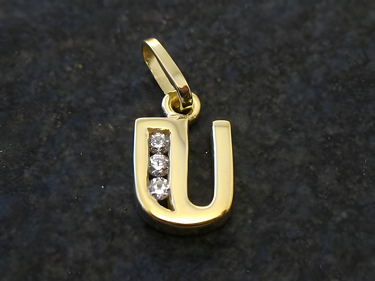 Anhänger in Form des Buchstabens U aus Gold, verziert mit drei Zirkonia, hergestellt von Juwelier Harnisch, elegantes Design, ideal als persönliches Geschenk oder Schmuckstück.