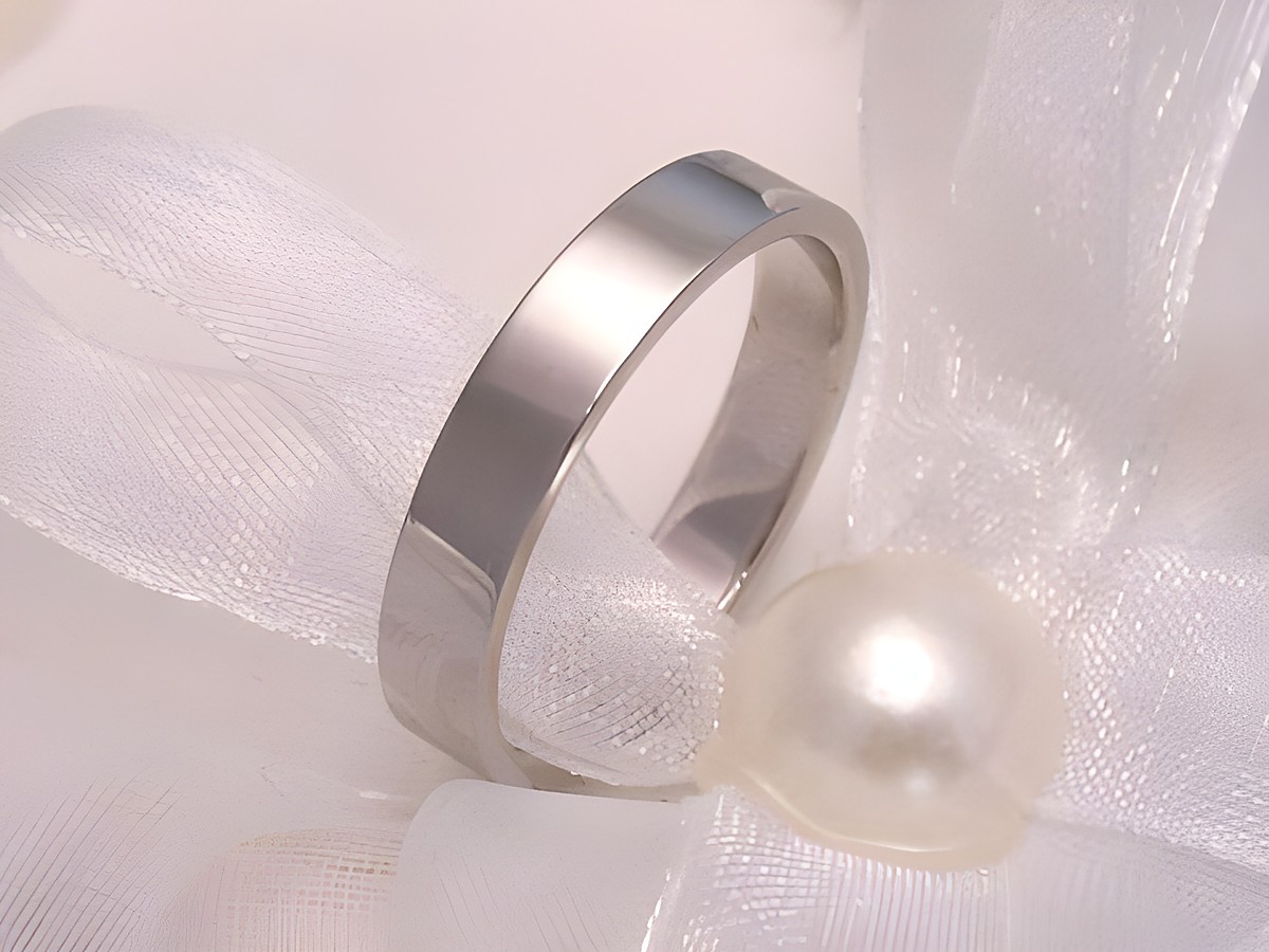 Trauring Ehering schönheit in Weißgold 333 Größe 65/20,7, Hersteller Juwelier Harnisch, elegant auf weißem Stoff mit Perle platziert. Ideal für den besonderen Anlass.