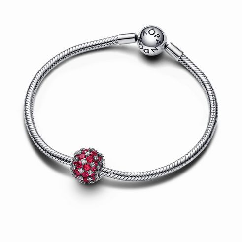 Rundes Pavé-Charm aus rosafarbenem Steinmix in Rot, eingefasst in hochwertigem Sterling Silber, plaziert auf einem eleganten Armband mit Pandora-Logo.