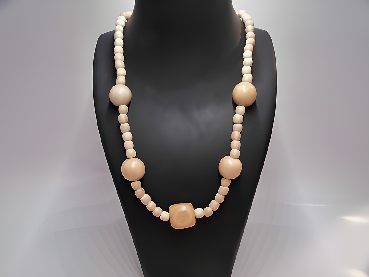 Eine Holzkette in naturbraun mit einem Durchmesser von 18 mm und einer Länge von 60 cm, hergestellt von Juwelier Harnisch, präsentiert sich als elegantes Schmuckstück.