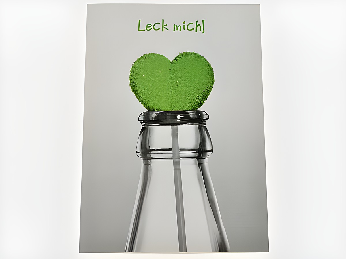 Geburtstagskarte mit einem grünen Herzlolli, der aus einer Flasche ragt. Die Karte zeigt eine auffällige Gestaltung mit der Aufschrift Leck mich. Hersteller Juwelier Harnisch.