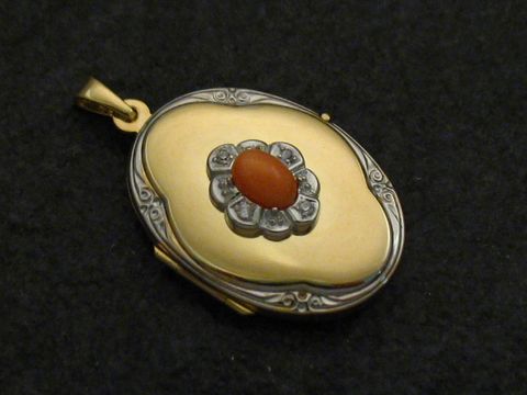 Kollier mit einem bicolor Medaillon aus Gold 585, das einen ovalen Cabochon aus Koralle in der Mitte und eine dekorative Umrandung besitzt, hergestellt von Juwelier Harnisch.
