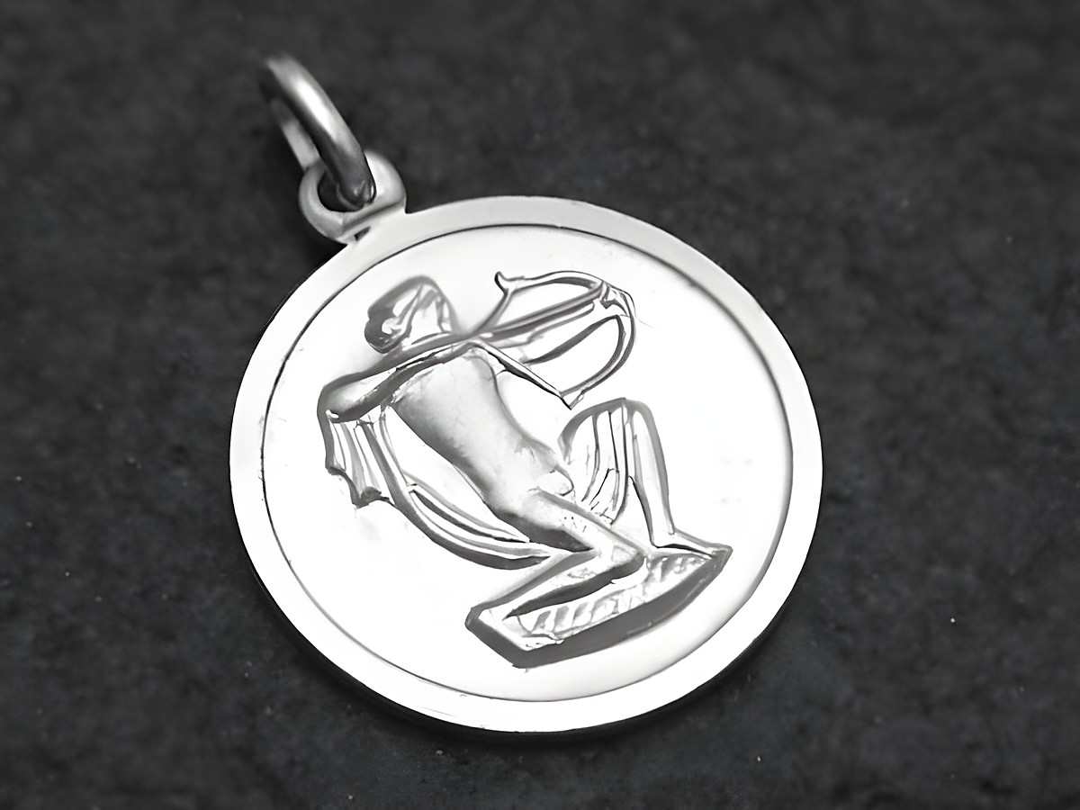 Runder Anhänger aus 925 Sterling Silber mit dem Motiv des Sternzeichens Schütze, dargestellt durch eine Figur, die mit einem Bogen zielt, Hersteller Juwelier Harnisch.