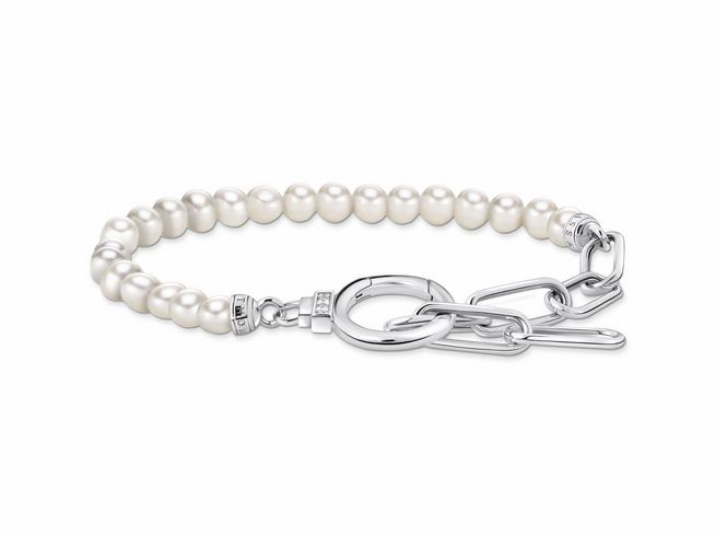 Elegantes Gliederarmband von Thomas Sabo aus Silber, verziert mit weißen Perlen und Zirkonia. Stilvolles Design mit einem besonderen Verschluss und raffinierter Optik.