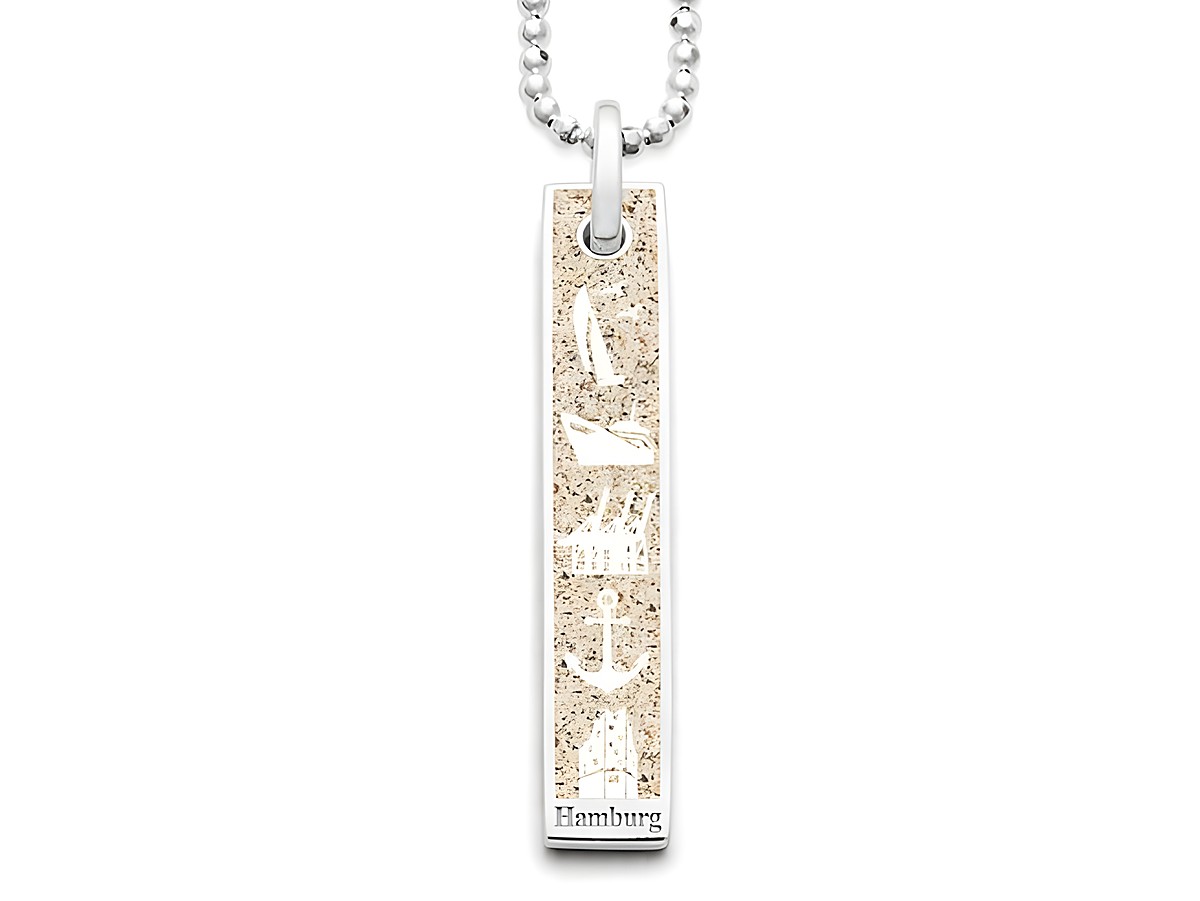 Ein eleganter Anhänger von DUR, der aus rhodiniertem Sterling Silber gefertigt ist. Der Schmuck zeigt auf einer sandfarbenen Fläche Symbole von Hamburg und wird an einer kette getragen.