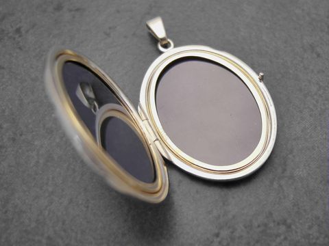 Gold Medaillon mit bourbonischer Lilie, 31 mm, Gold 585, Hersteller Juwelier Harnisch, ovales Design, geöffnet und zeigt Platz für zwei Bilder.