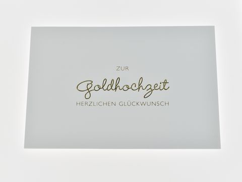 Hochzeitskarte in elegantem Design mit goldener Schrift auf weißer Karte, Hersteller Juwelier Harnisch, ideal für Glückwünsche zur Goldhochzeit.