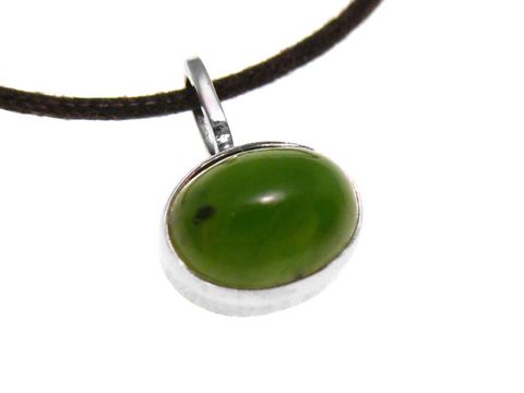 Ein ovaler Goldanhänger aus Weißgold mit grünem Jadebesatz, an einer braunen Schnur befestigt, hergestellt von Juwelier Harnisch.