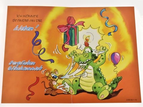 Eine lustige Geburtstagskarte zeigt einen Comic-Dino mit einem Geschenk und einem Luftballon, begleitet von einer kleinen Maus. Der Hintergrund ist orange, mit bunten Feierlichkeiten und dem Text "Herzlichen Glückwunsch".