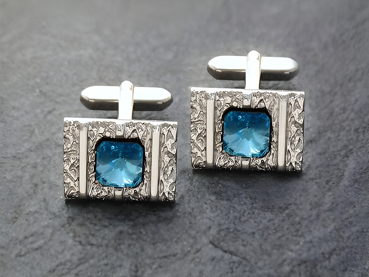 Silberfarbene Manschettenknöpfe mit rhodinierten Strass-Steinen in blauer Farbe, hergestellt vom Juwelier Harnisch, elegant und stilvoll für besondere Anlässe.