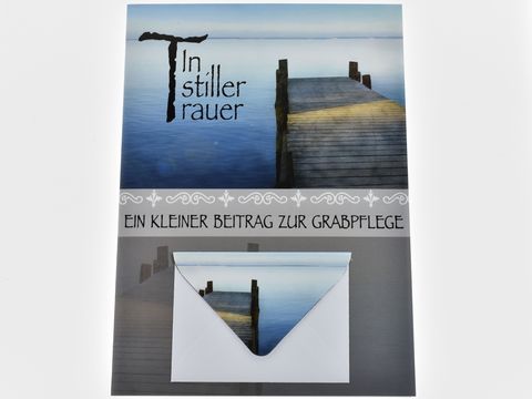 Karte mit Umschlag, bedruckt mit einem Steg am See und dem Text In stiller Trauer sowie einem Hinweis zu Grabpflege. Hersteller ist Juwelier Harnisch.