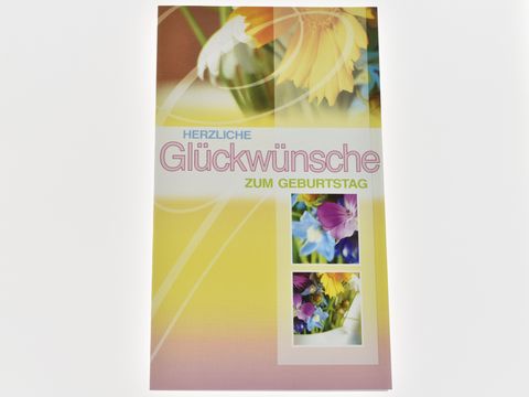 Bunte Geburtstagskarte mit dem Text Herzliche Glückwünsche zum Geburtstag, dekoriert mit farbenfrohen Blumenmotiven, herausgegeben vom Juwelier Harnisch.