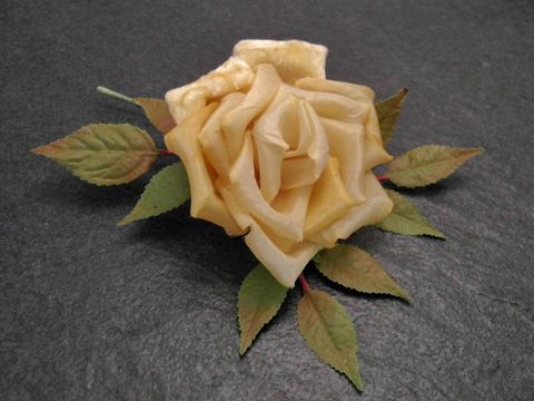 Verspielter Haarschmuck und Brosche in Form einer sonnengelben Blume aus Samt-Mix mit grünen Blättern, Hersteller Juwelier Harnisch, ideal für besondere Anlässe.