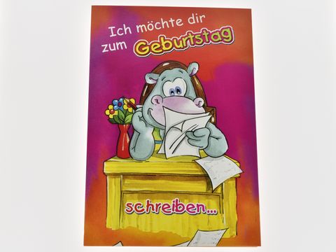 Eine bunte Geburtstagskarte mit einem lächelnden Nilpferd, das an einem Tisch sitzt und einen Brief liest. Im Hintergrund stehen Blumen und auf dem Tisch liegen Papierblätter.