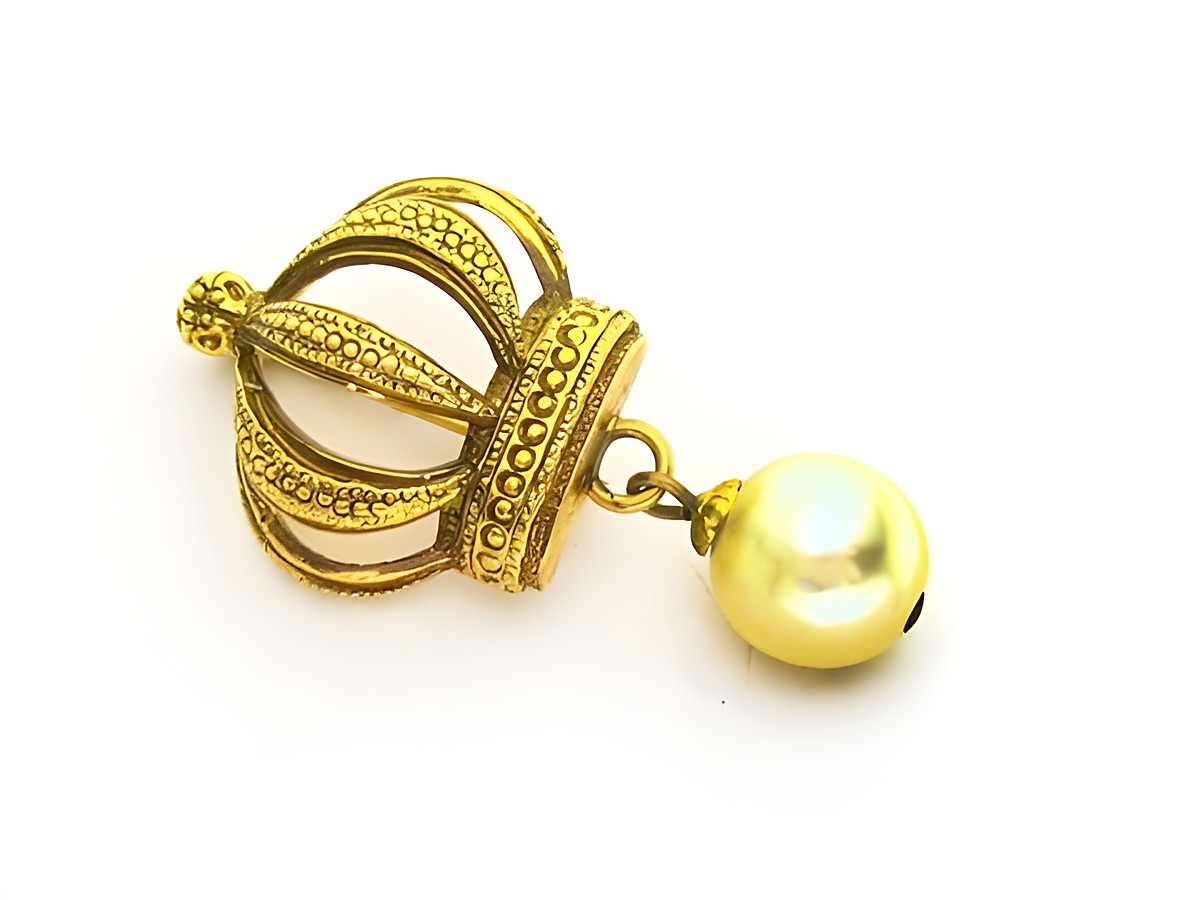 Eine goldfarbene Brosche im sexy City Look mit einer Zuchtperlen-Imitation, hergestellt von Juwelier Harnisch, verleiht jedem Outfit einen eleganten Akzent.
