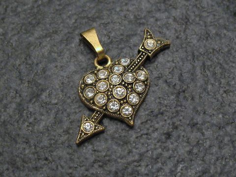Weißer Strass Anhänger in Form eines Herzens mit Pfeil, glänzende Strasssteine, goldfarbener Anhänger, ideal für einen sexy City Look, Hersteller: Juwelier Harnisch.