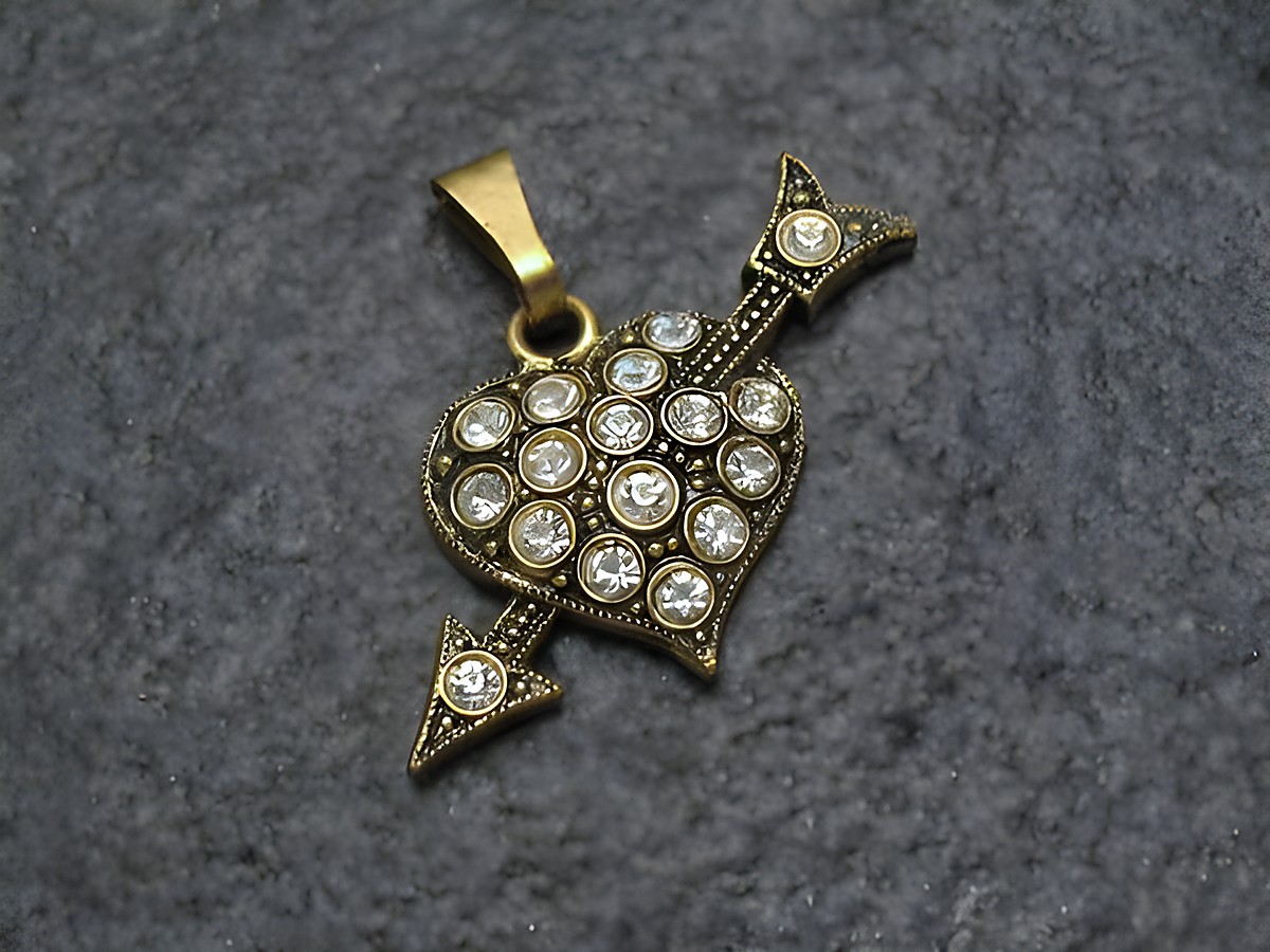 Weißer Strass Anhänger in Form eines Herzens mit Pfeil, glänzende Strasssteine, goldfarbener Anhänger, ideal für einen sexy City Look, Hersteller: Juwelier Harnisch.