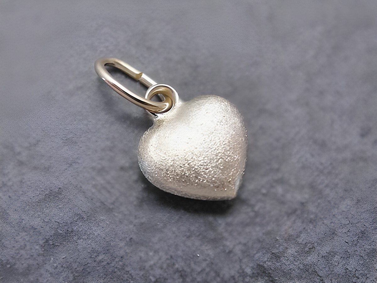 Ein niedlicher Herzanhänger aus Gold, hergestellt von Juwelier Harnisch, mit plastischer Struktur und glänzender Oberfläche. Ideal als Geschenk oder für persönlichen Schmuck.