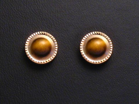 Ohrringe aus Tigerauge mit goldenen Ohrsteckern, Hersteller Juwelier Harnisch, verziert mit weiteren Steinen, elegantes Design auf schwarzem Hintergrund.