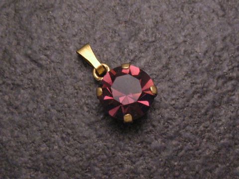 Lila Strass Anhänger im sexy City Look, rund, hergestellt von Juwelier Harnisch, glänzend mit goldfarbener Öse, ideal für schicke Outfits, bietet einen eleganten Akzent.