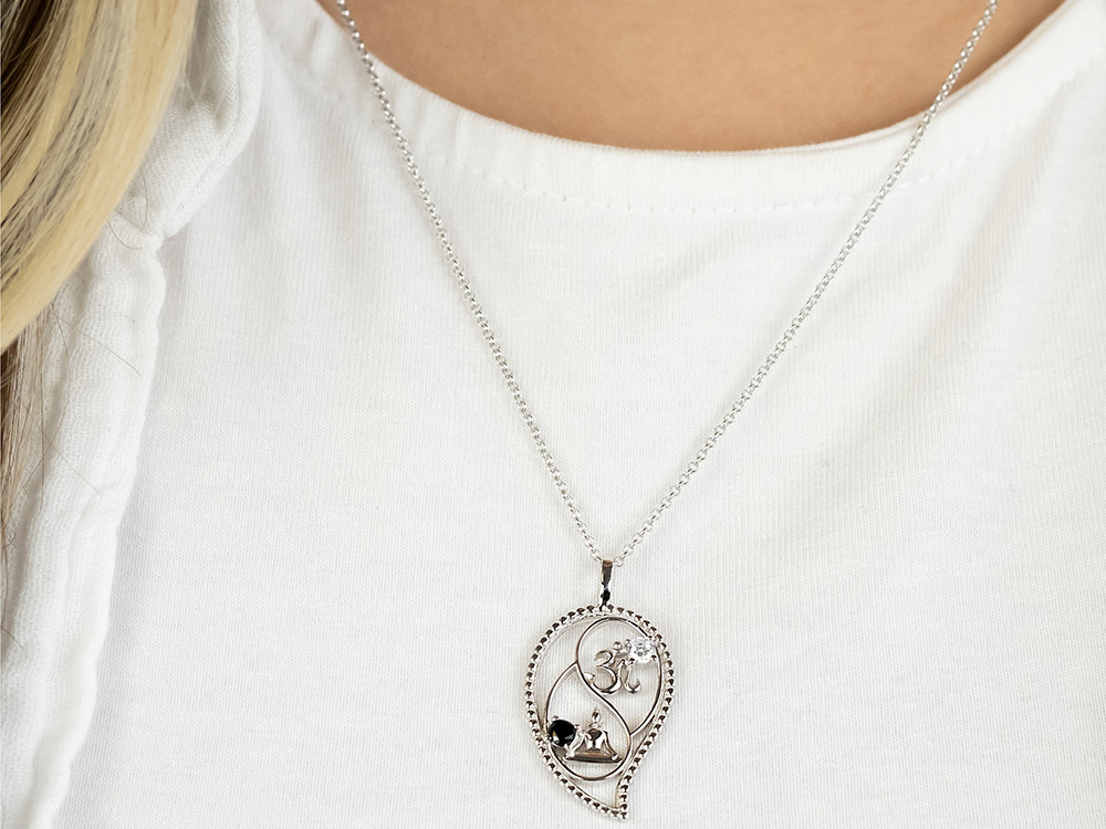 Silberne Engelsrufer Kette mit Yin Yang Symbol und Zirkonia, Länge 42 cm plus 4 cm Verlängerung, präsentiert an einem schlichten weißen Oberteil.