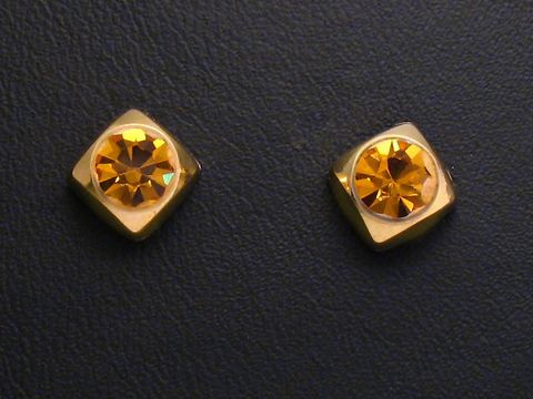 Zwei facettierte Citrin Ohrstecker in Goldfassung vom Juwelier Harnisch, mit schimmernden Details und modernen Design, ideal für elegante Anlässe.