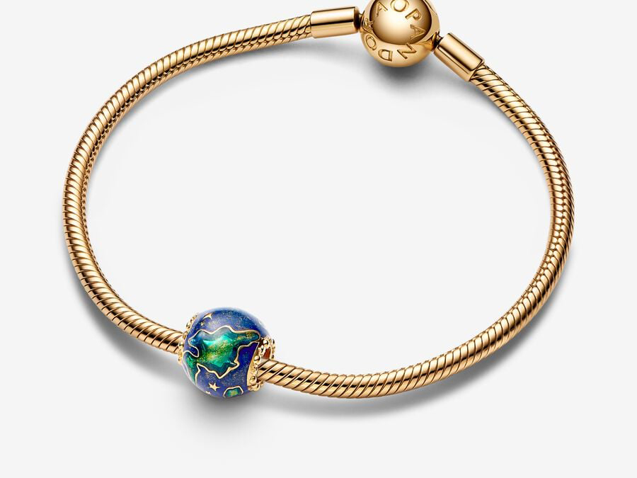 Pandora Charm mit Planet Erde Motiv, gefertigt aus gelbgold vergoldetem Material, verziert mit multicolor Emaille in blau und grün, auf einem eleganten Armband in Drahtoptik.