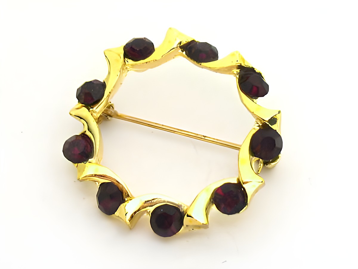 Rote Strass Brosche im Granatlook, rundlich gefasst, von Juwelier Harnisch, mit dekorativen goldfarbenen Elementen und dunklen Strasssteinen, ideal für elegante Akzente.