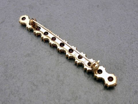 Granat Schmuck Brosche 56,9 mm in dezentem Golddesign mit mehreren Granatsteinen, hergestellt von Juwelier Harnisch. Elegantes Accessoire für stilvolle Outfits.