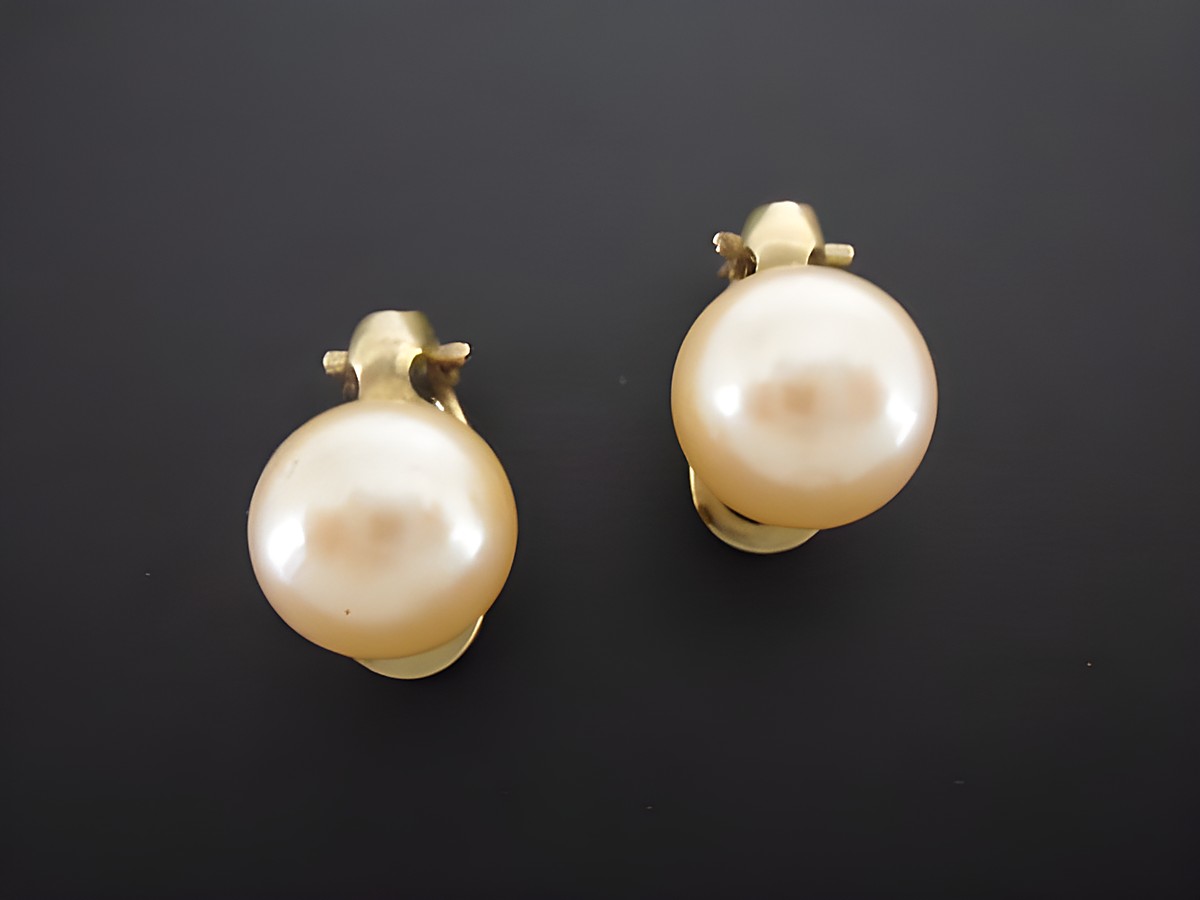 Ohrclip in zeitlosem Design mit goldfarbener Fassung und synthetischen Zuchtperlen, Hersteller Juwelier Harnisch, ideal für elegante Anlässe.